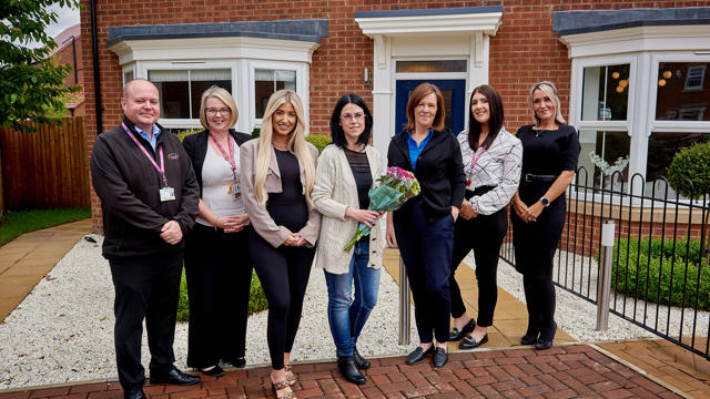 Employees with Sue Young (Executive Director of Investment) celebrating reaching a new milestone of building 4000 new homes since 2005.