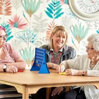 Image of tenants playing connect 4 at one of our independent living properties.